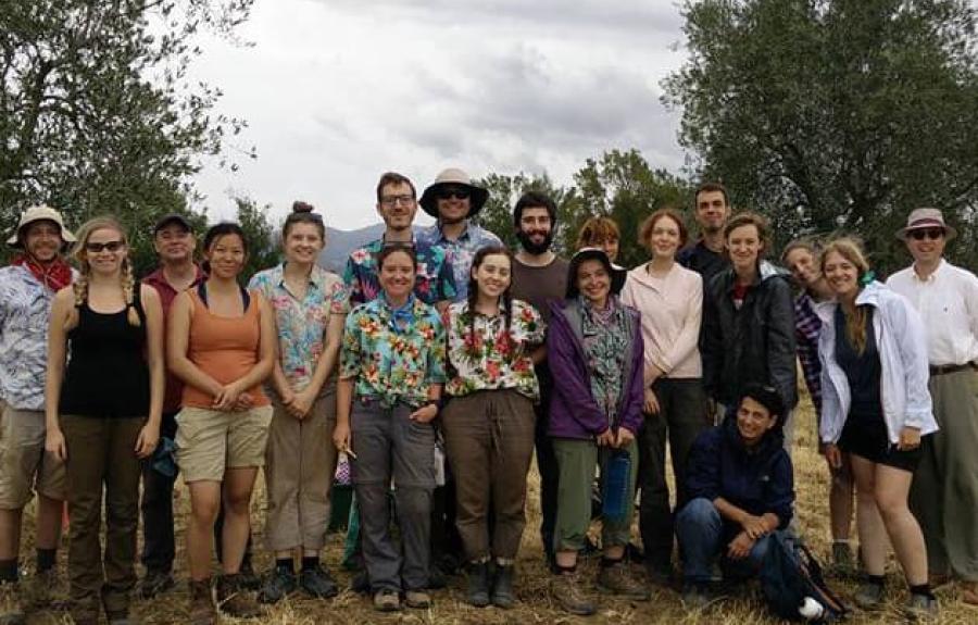 The whole excavation team poses for a photo on a rare rainy day with a backdrop of rolling Tuscan hills.
