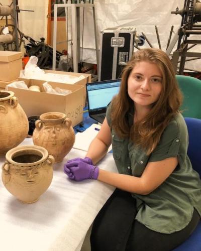 Danielle Vander Horst, M.A. '19, with a collection of face pots during a 2018 research trip at the Colchester and Essex Museum, Colchester, United Kingdom